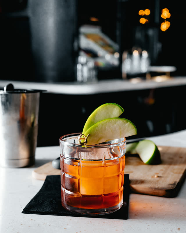 Old fashioned cocktail with apple slices