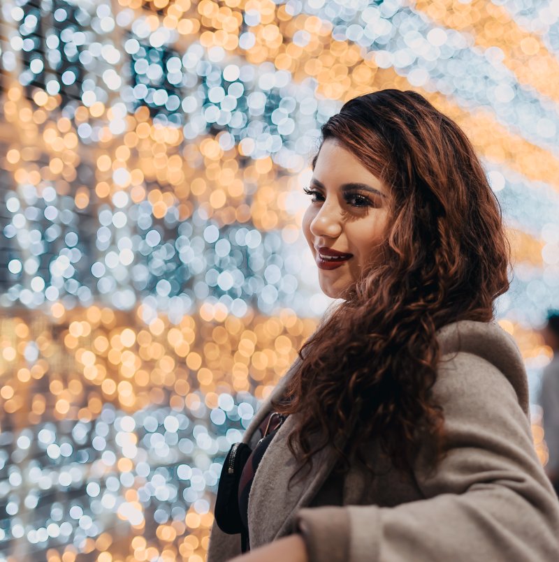 Portrait against glowing holiday bokeh lights