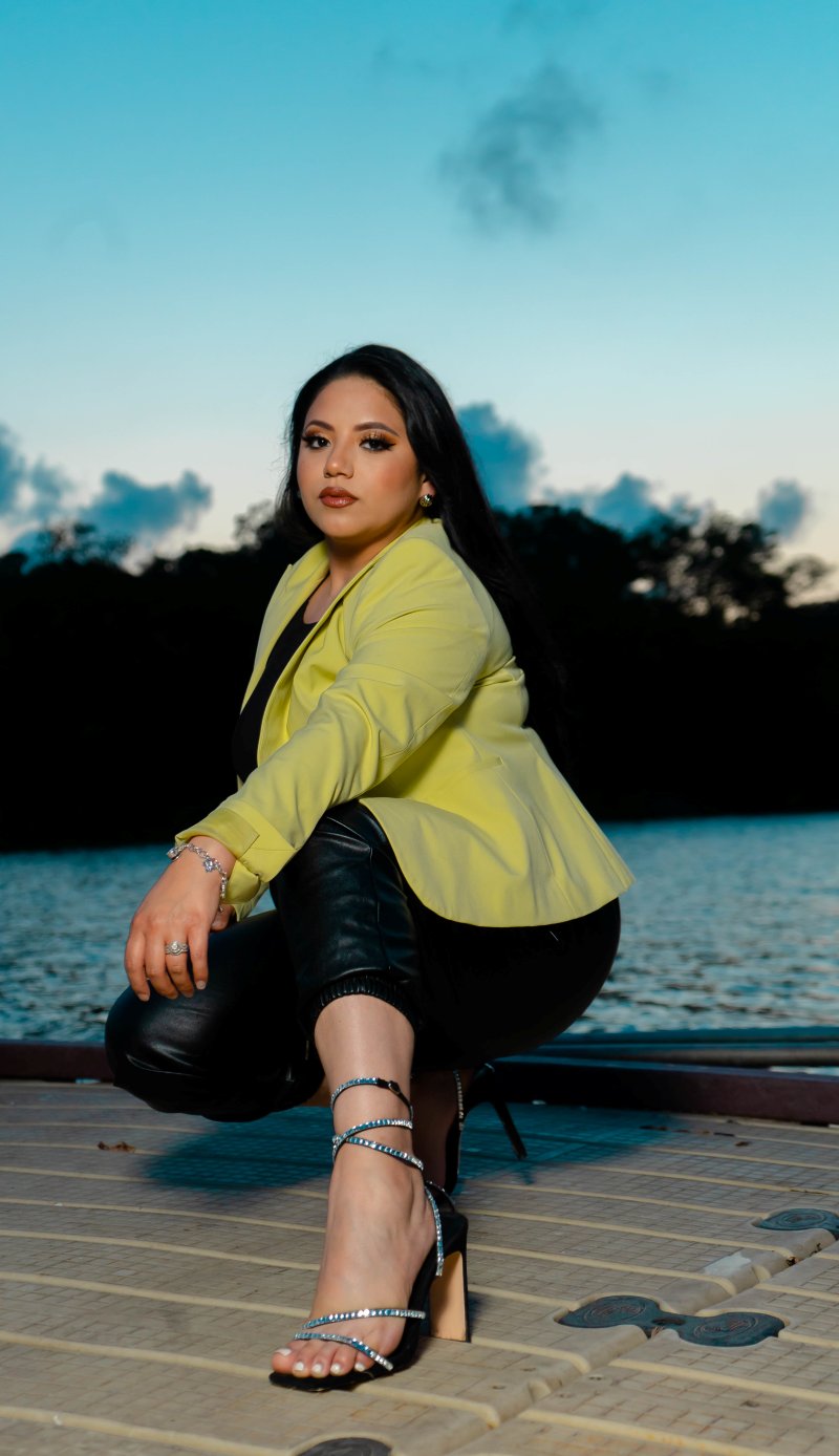 Fashion brand portrait — seated on dock at dusk, yellow blazer